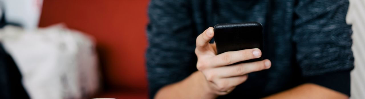 Jugendlicher hält Handy in der Hand